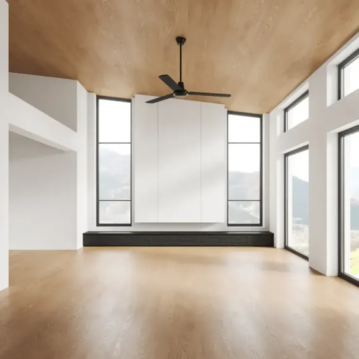 Una sala de estar vacía con un ventilador de techo y muchas ventanas.