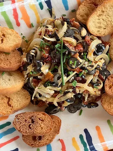 Un plato de comida con galletas y aceitunas en un plato colorido.