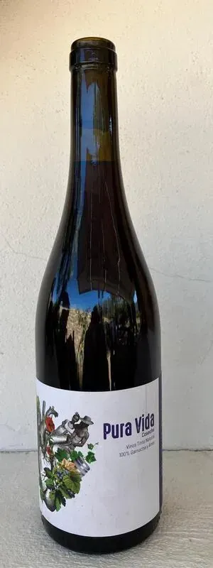 Una botella de vino con un pájaro en la etiqueta está sobre una mesa.