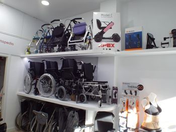 Estanterías con varias sillas de ruedas y ayudas para la movilidad en una sala de exposición