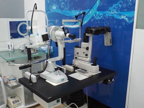 Equipo de clínica dental sobre una encimera, incluidos un microscopio, una lámpara y otros dispositivos médicos.