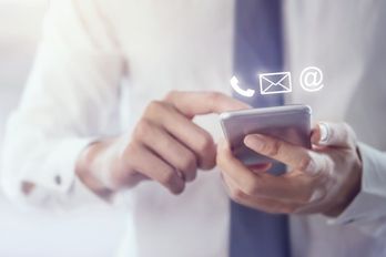 Mies pitää puhelinta kädessään