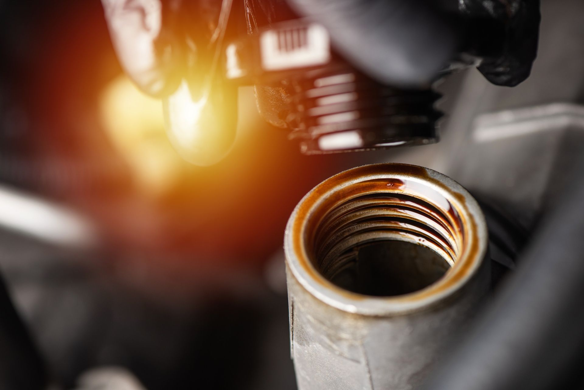Un primer plano de una persona vertiendo aceite en el motor de un automóvil.