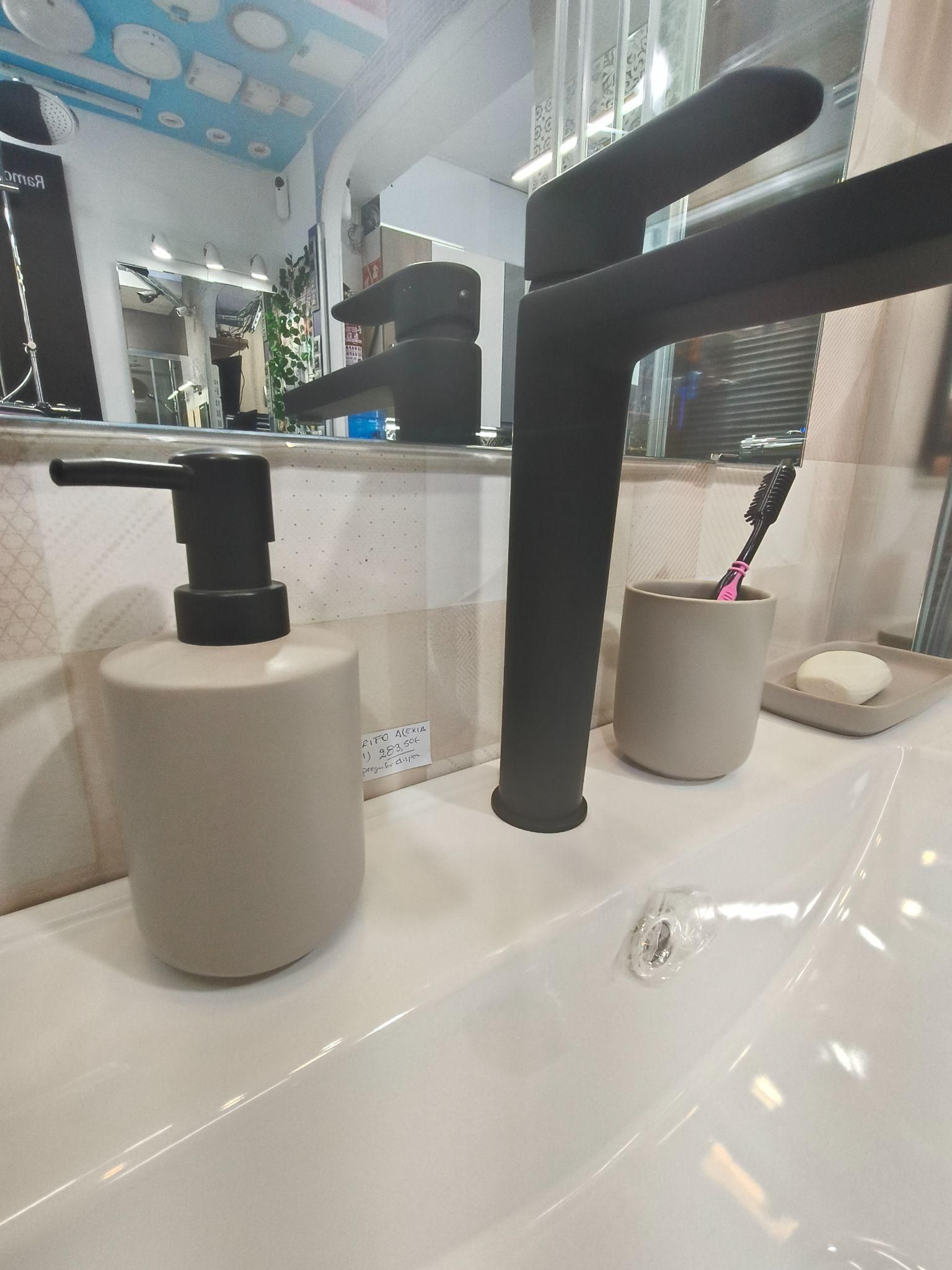Un lavabo de baño con grifo negro, dispensador de jabón y soporte para cepillos de dientes.