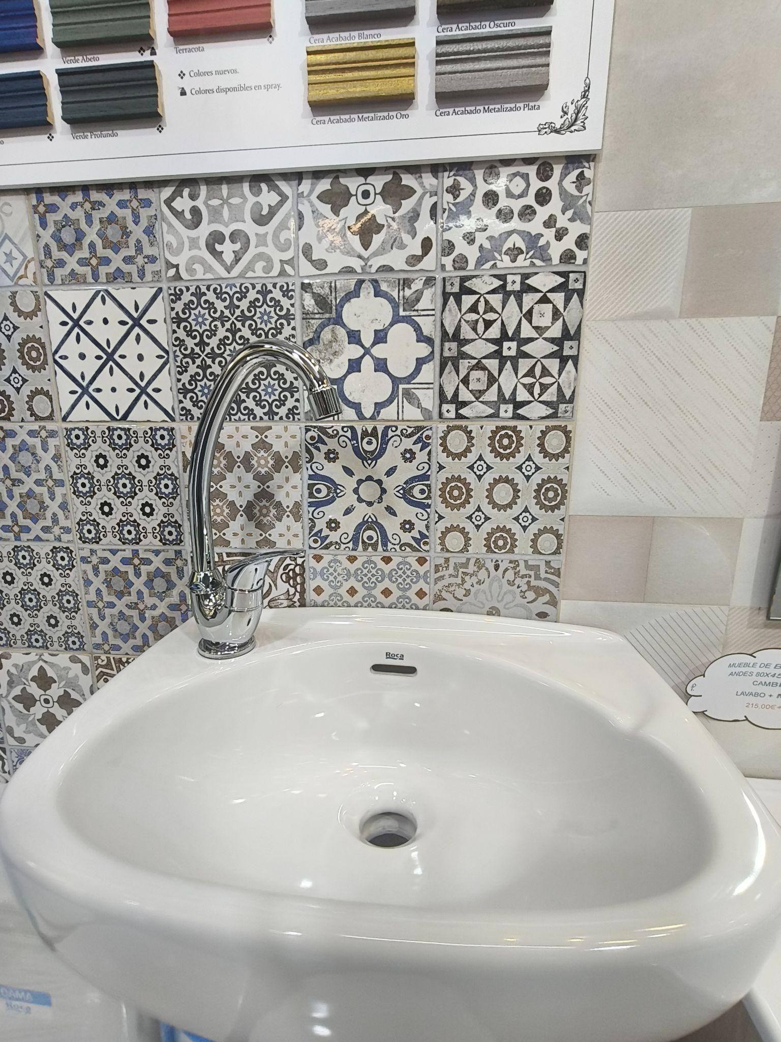 Un lavabo de baño con grifo y azulejos en la pared.