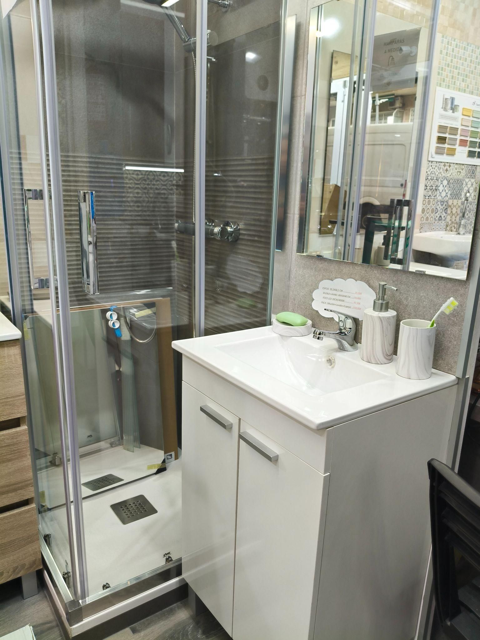 Un baño con lavabo, espejo y cabina de ducha.