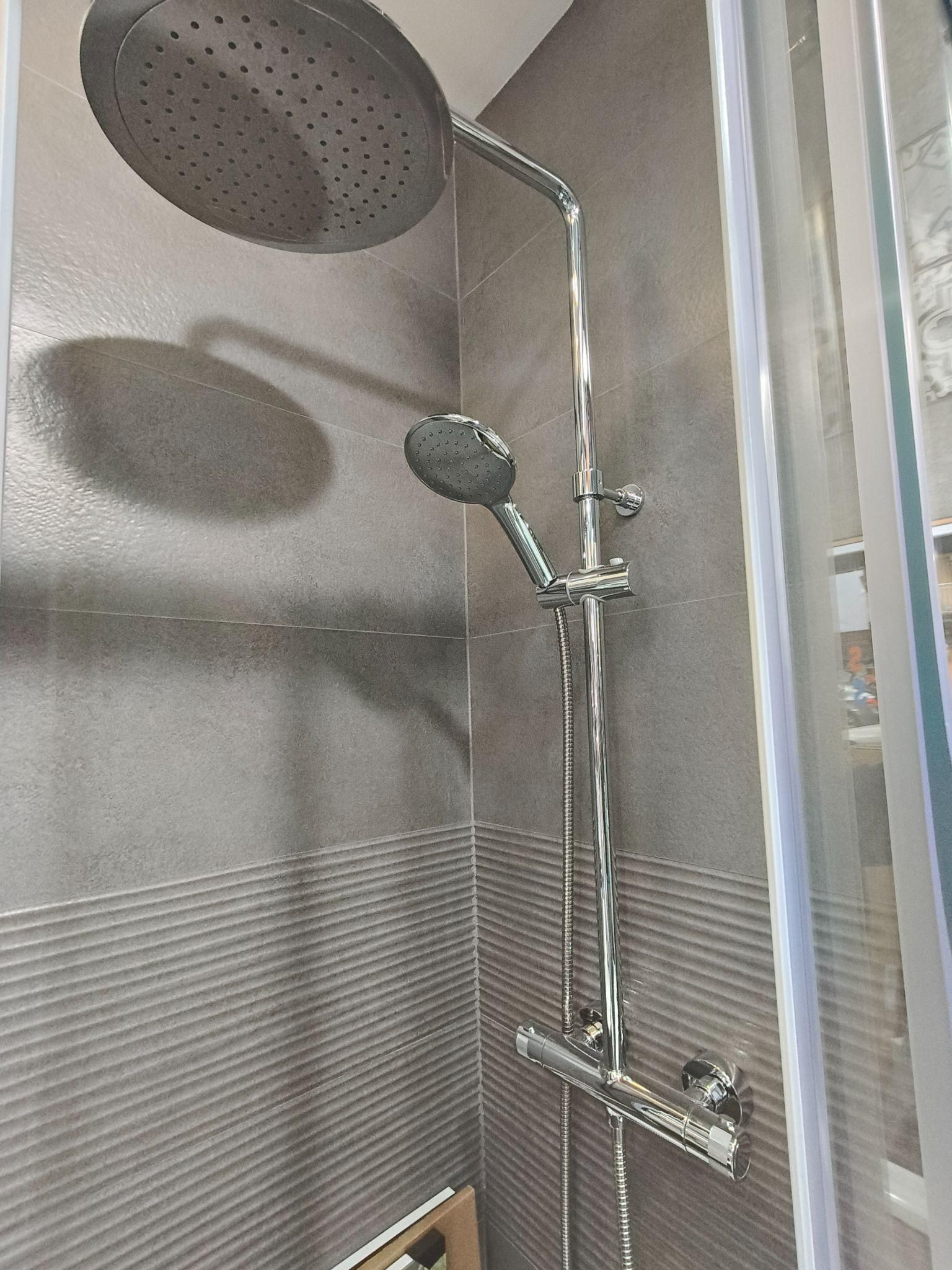 Un cabezal de ducha cuelga de la pared en un baño.