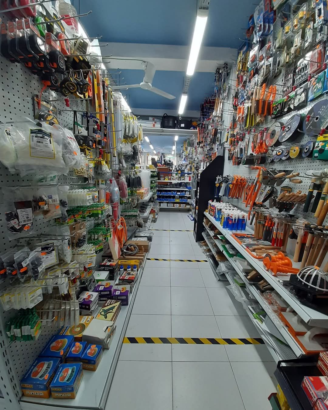 Una pared llena de herramientas y pinturas en una tienda.