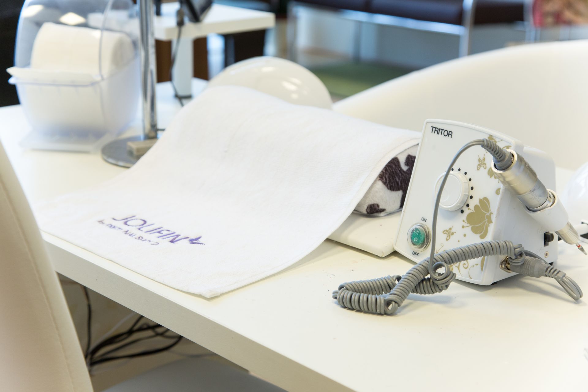 Ein weißes Handtuch liegt auf einem weißen Tisch neben einer Maschine.