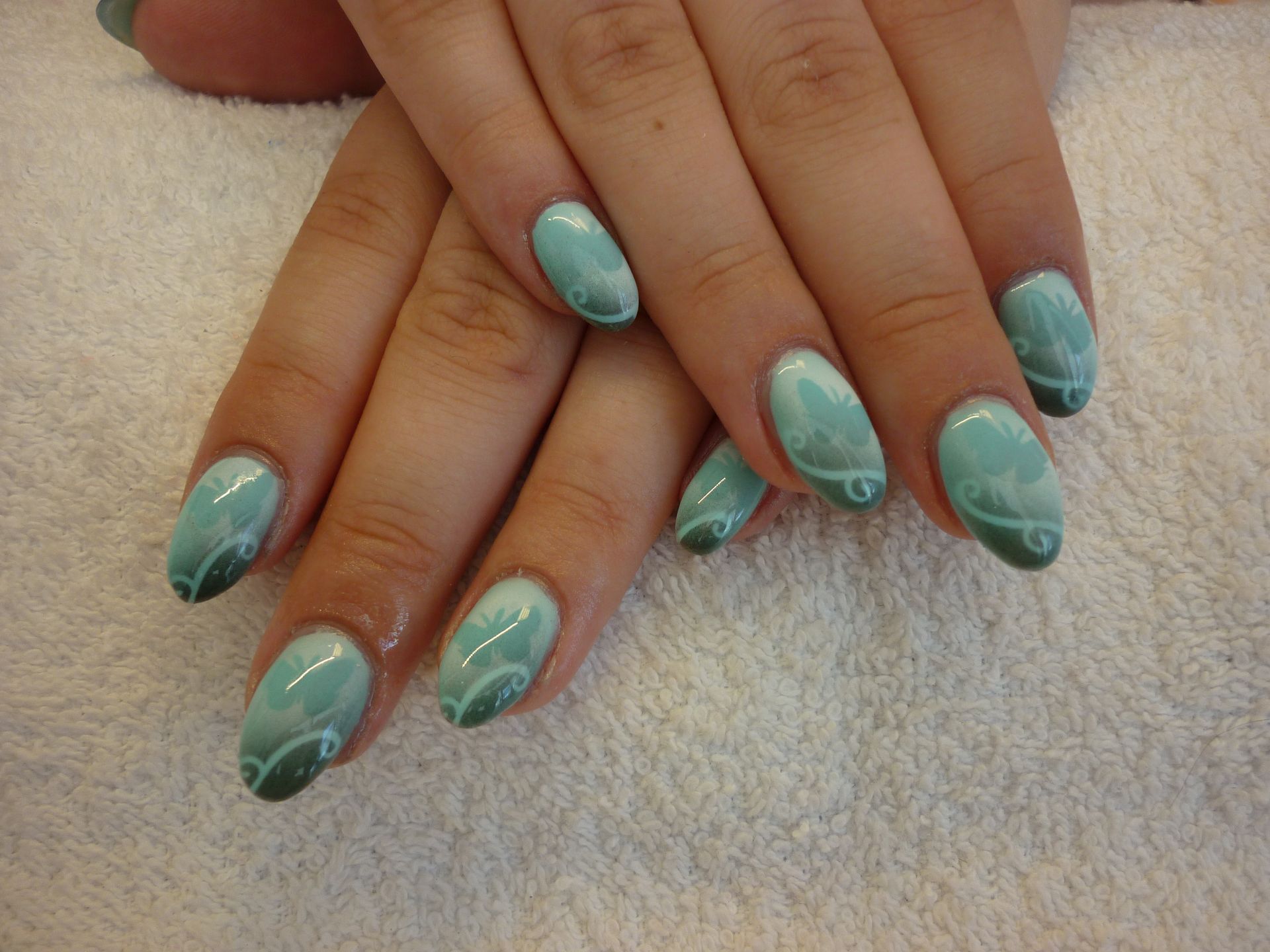 Eine Nahaufnahme der Nägel einer Frau auf einem weißen Handtuch