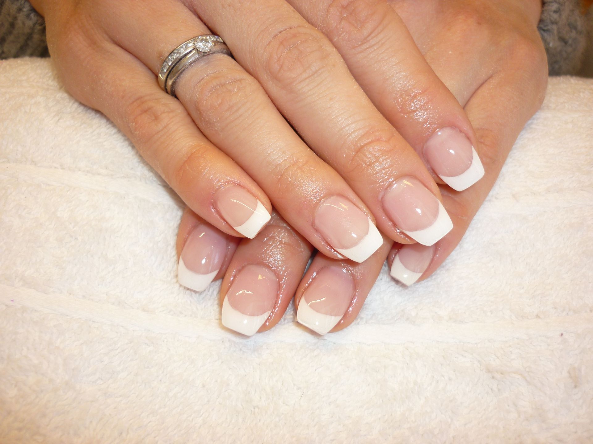 Eine Nahaufnahme der Nägel einer Frau mit einem Ring am Finger