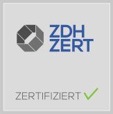 Ein Logo für zdh zert mit einem grünen Häkchen.