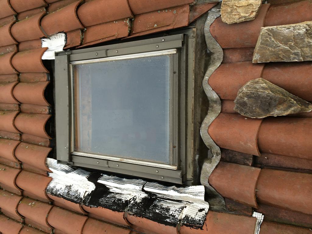 Velux sur un toit en tuile endommagé