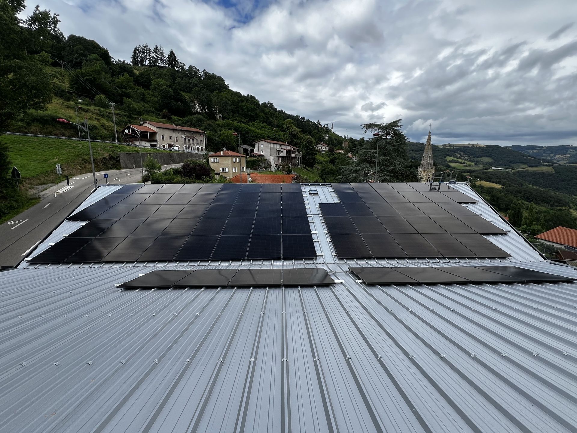 Plusieurs plaques de panneaux solaires posées sur un toit en bac acier