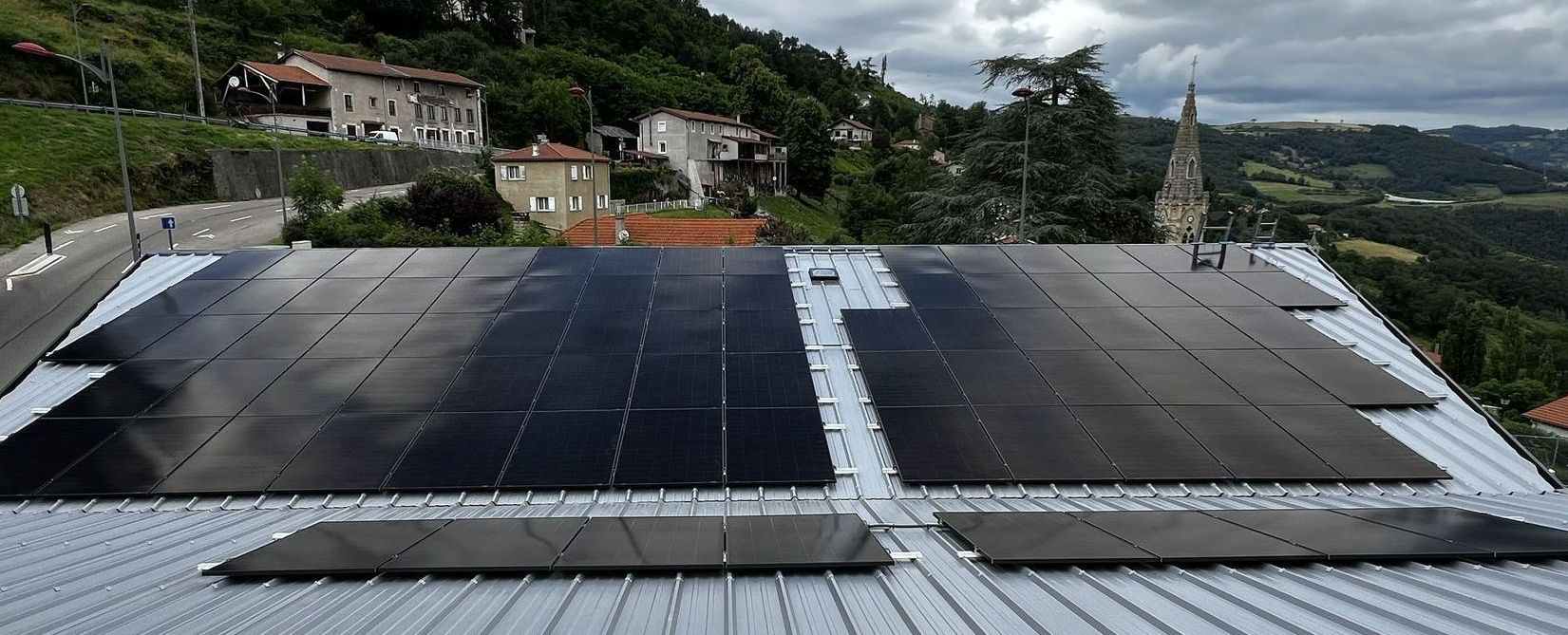 Des panneaux solaires posés sur un toit en bac acier gris
