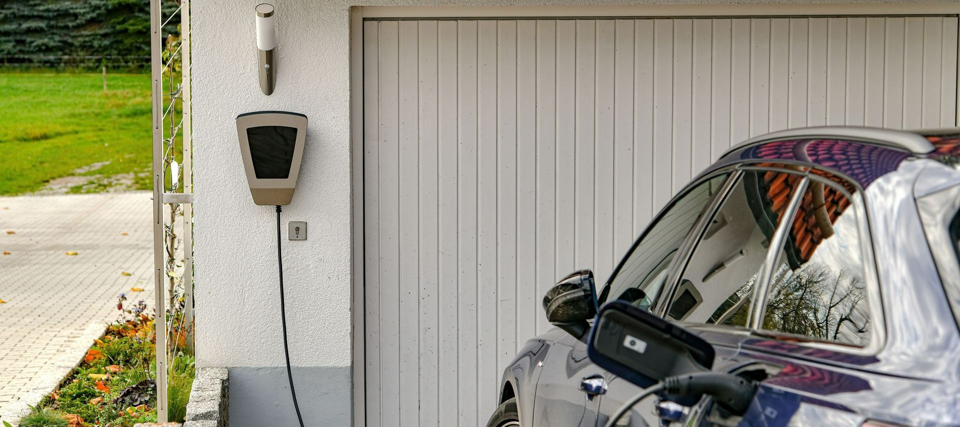 Borne de recharge prêt d'une porte de garage qui charge une voiture