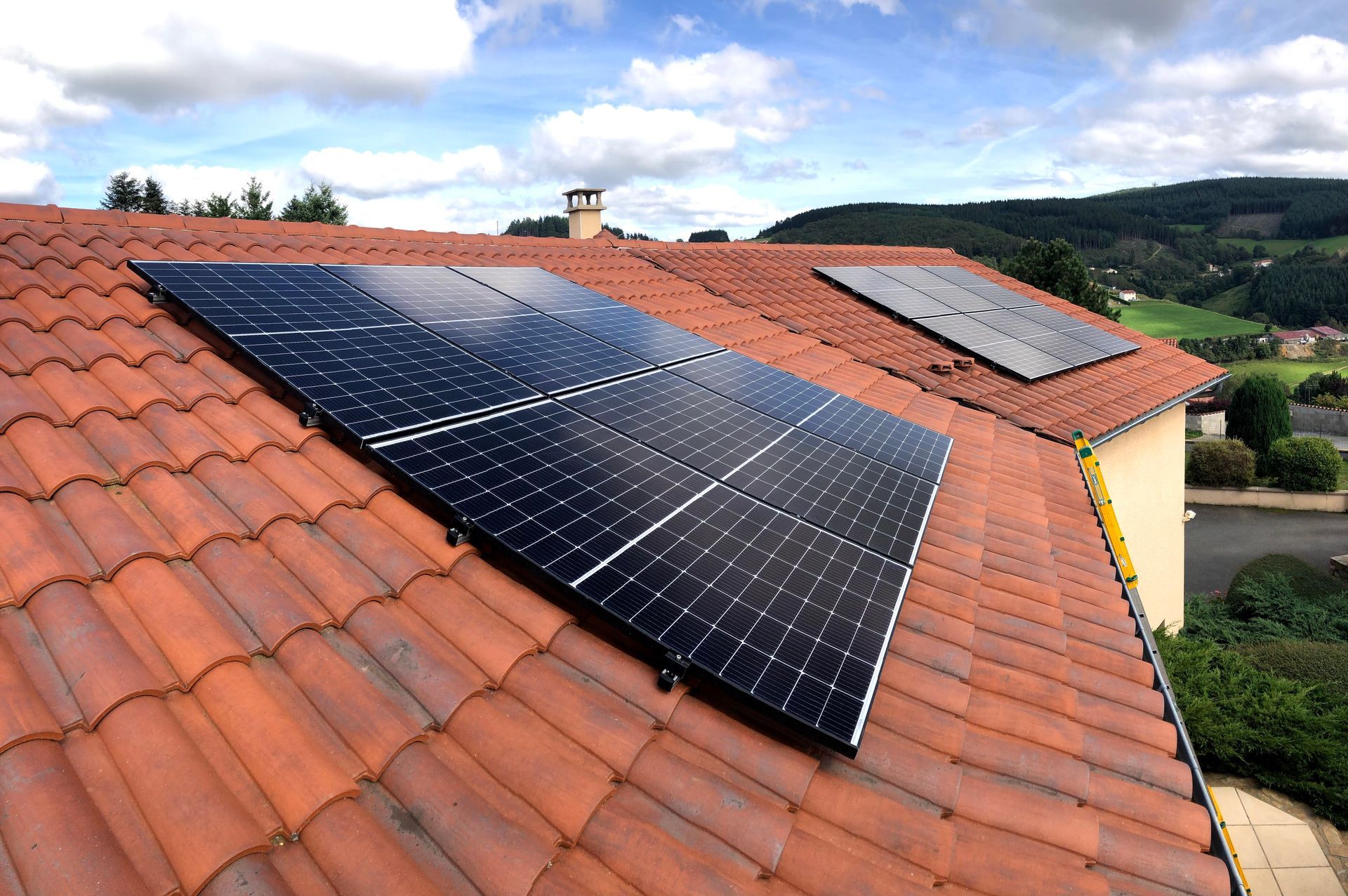 Deux panneaux solaires installés sur un toit en tuiles