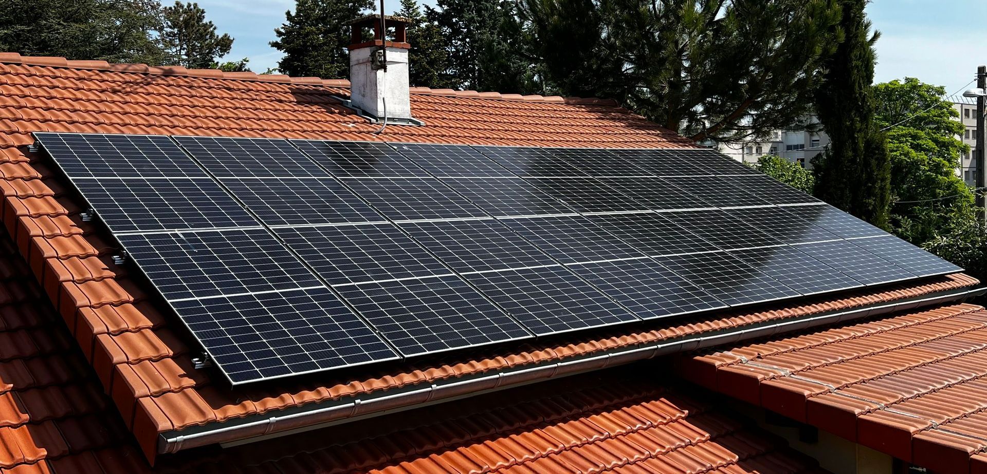 Rangée de panneaux photovoltaïques sur une partie de toiture en tuile