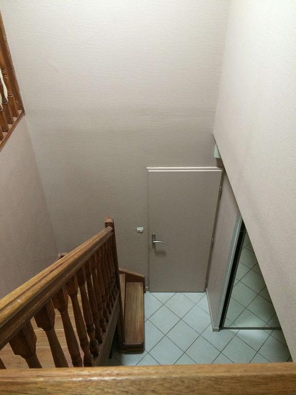 Vue d'en haut d'une cage d'escalier sur une porte ouverte