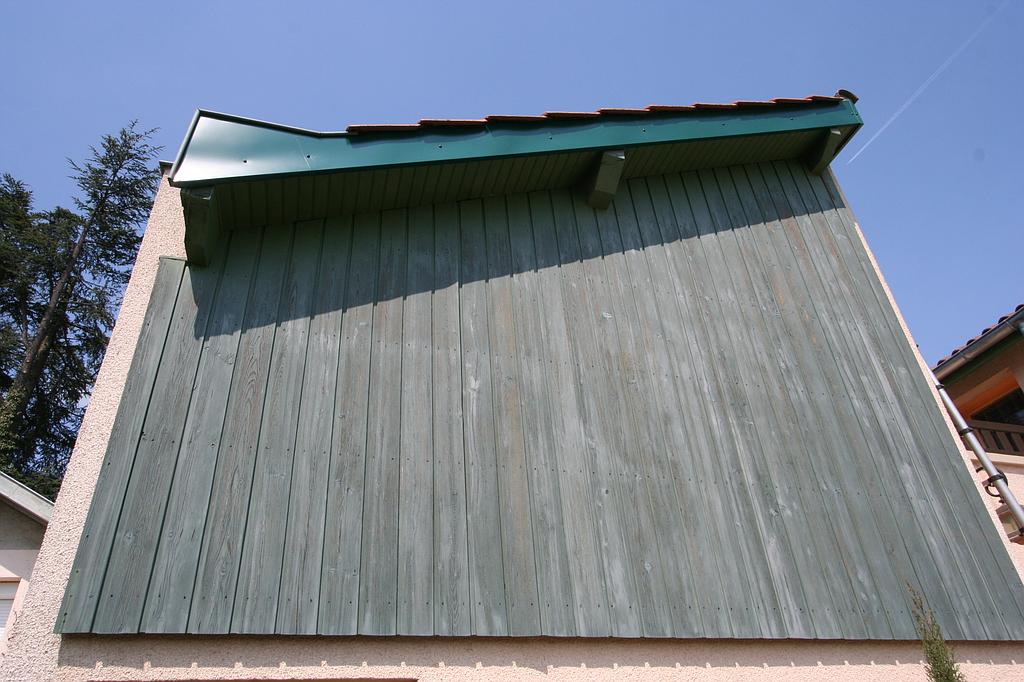 Planches de bois grises posées sur le flanc d'une maison