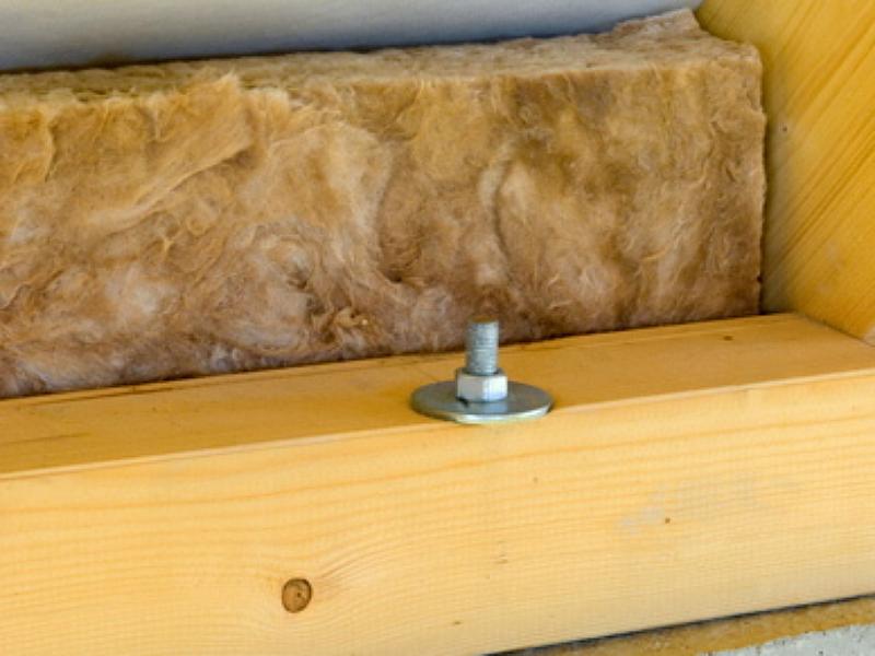 Morceau de charpente avec une vis et une plaque isolante