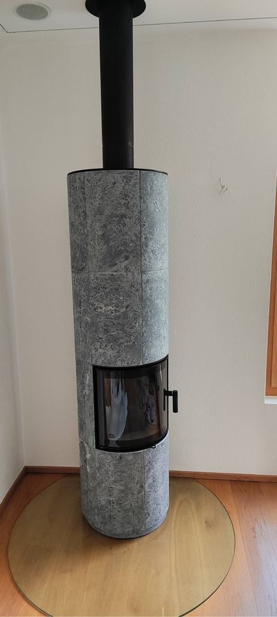 Flur mit welligem, schwarz-grauem Teppich, hellblauer Tür links und beigen Wänden.