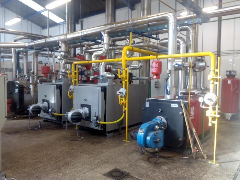 Una fila de calderas están alineadas en un almacén.
