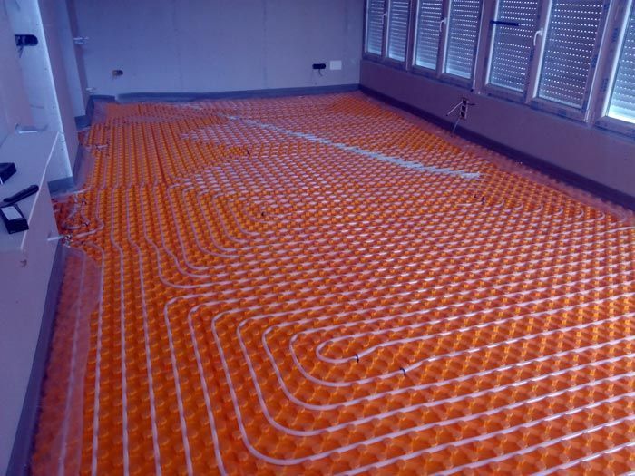 Una habitación con muchas ventanas y un suelo naranja.