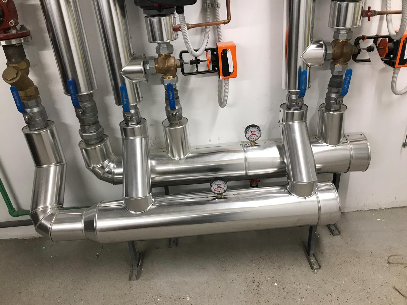 Un montón de tubos de acero inoxidable están alineados en una habitación.