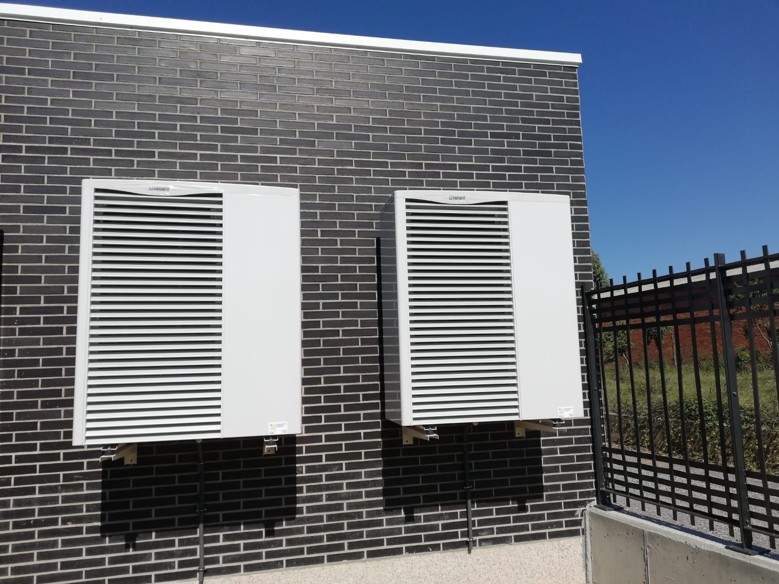 Un edificio de ladrillo con dos contraventanas blancas a los lados.