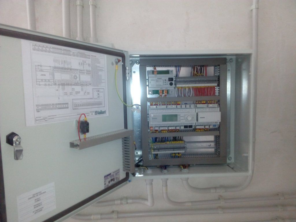 Una caja eléctrica con la puerta abierta y un montón de cables saliendo de ella.