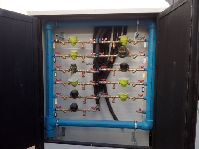 Una caja con un montón de tubos y válvulas dentro.