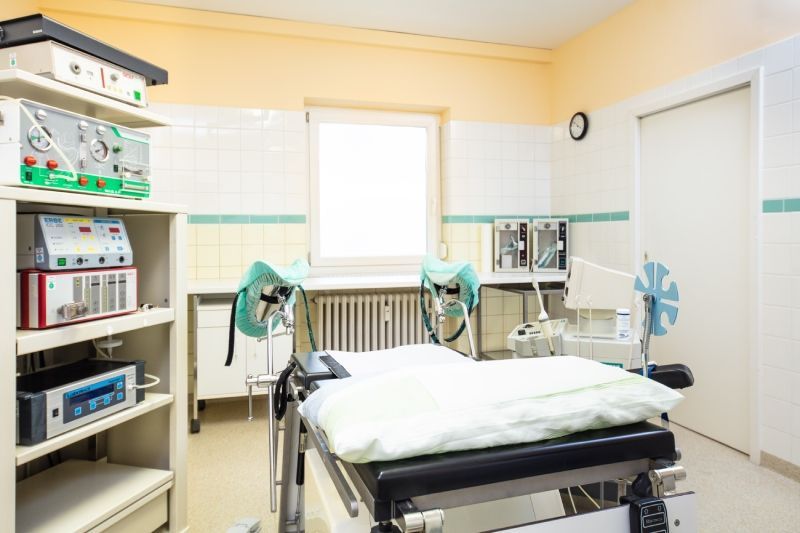 Operationssaal mit OP-Tisch, medizinischen Geräten und Fenster.
