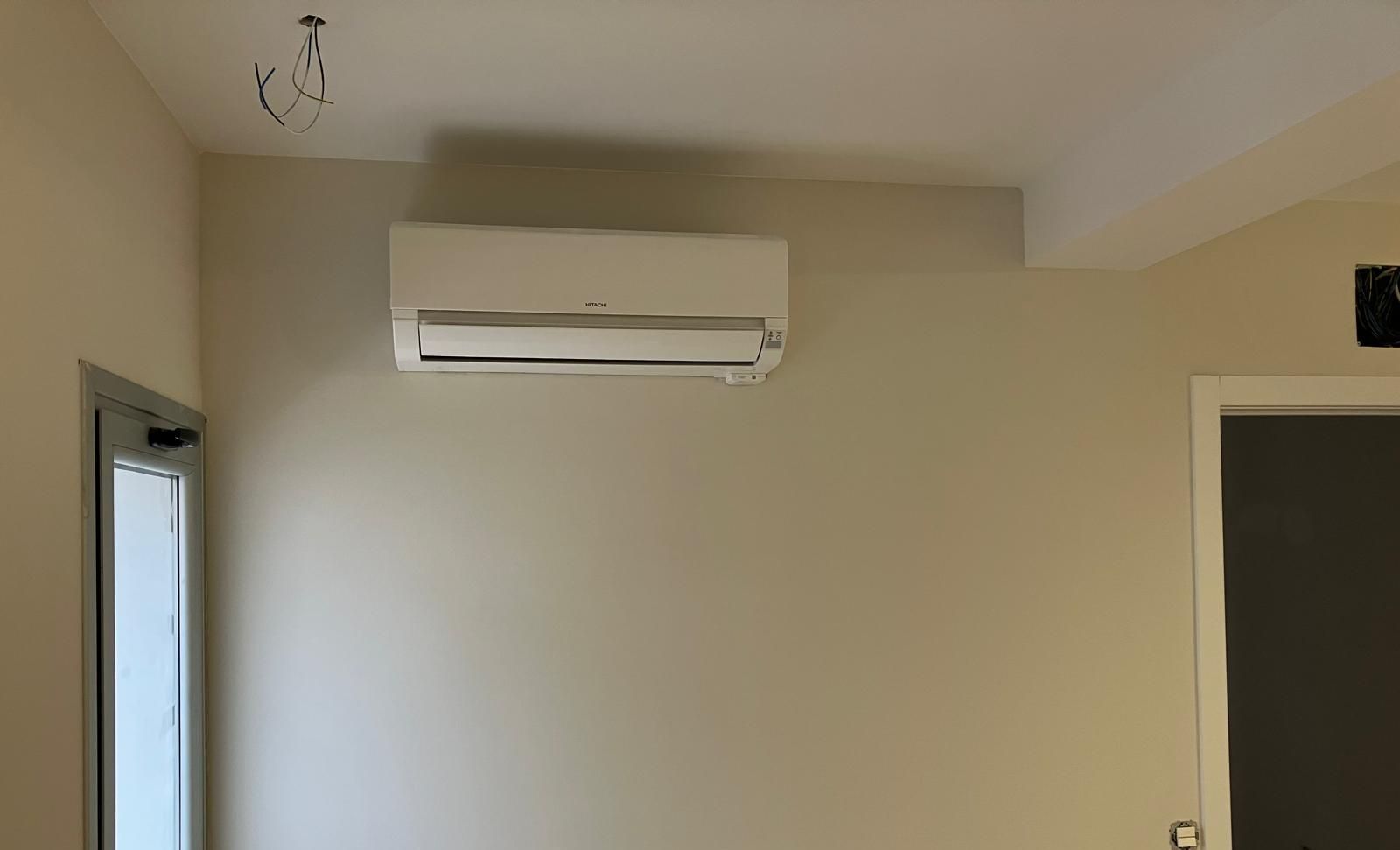 Una habitación con una ventana y un aire acondicionado montado en la pared.