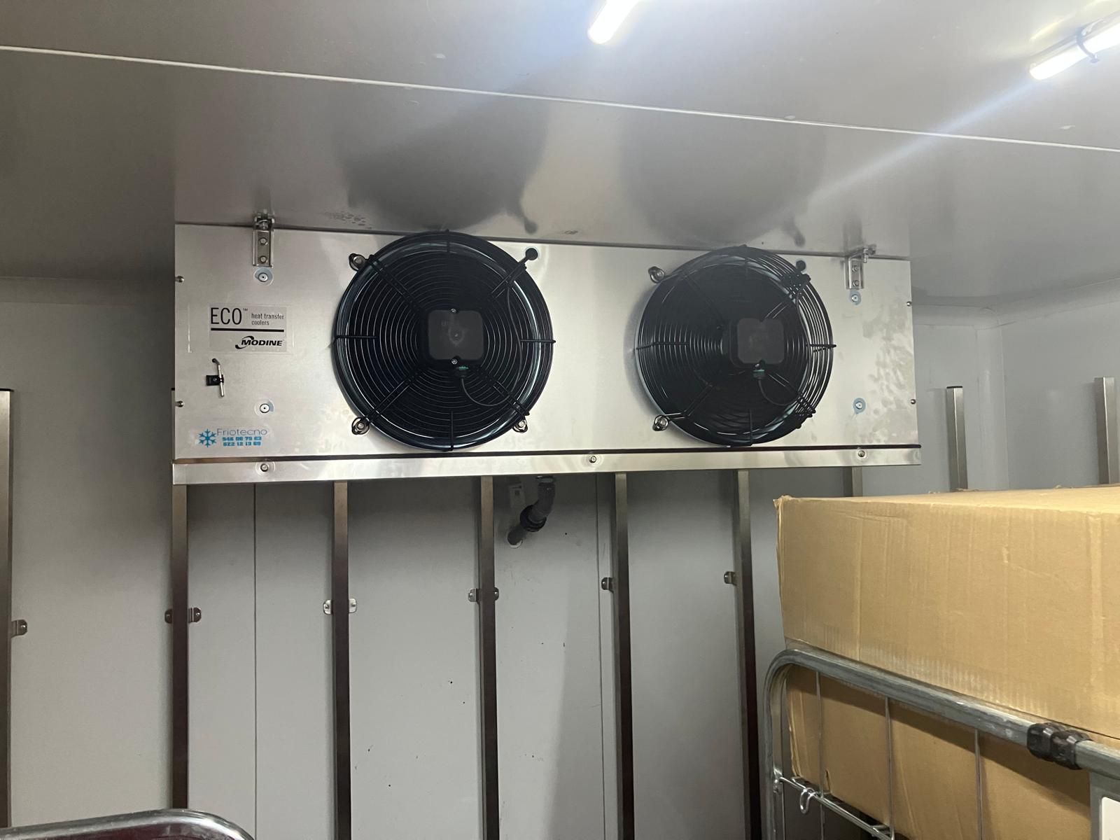 Una puerta blanca con una manija azul está colgada en una pared.