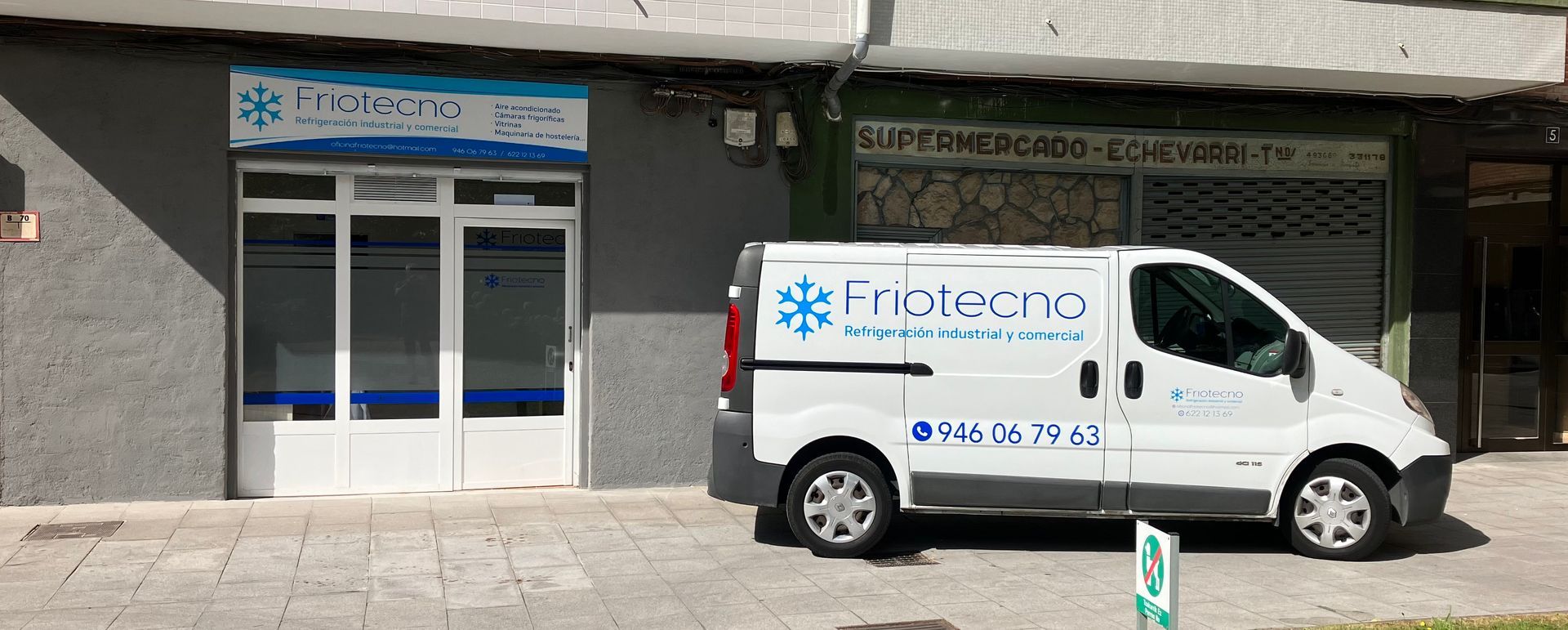 Una camioneta blanca está estacionada frente a un edificio.