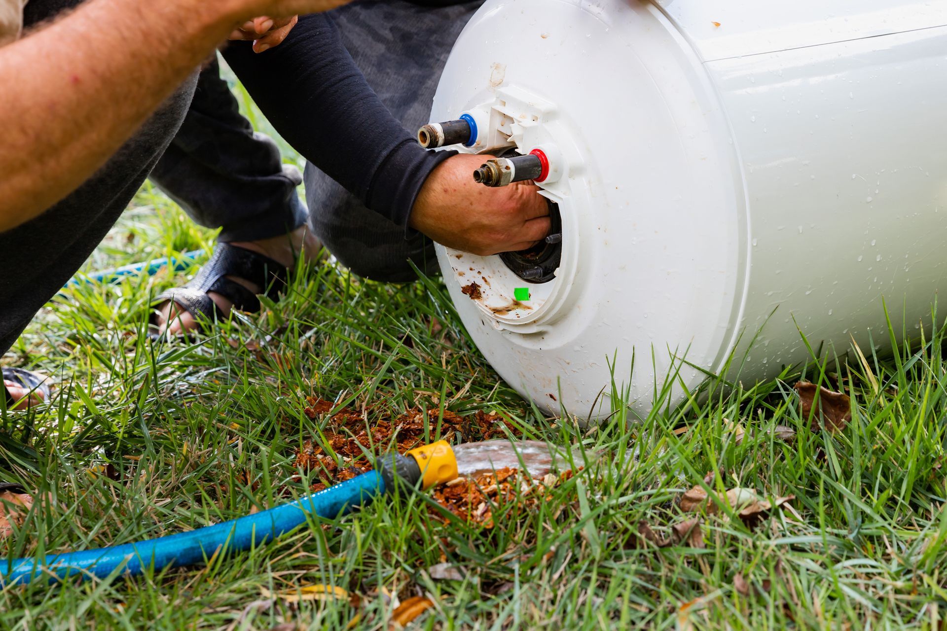 Homme qui nettoie un chauffe-eau