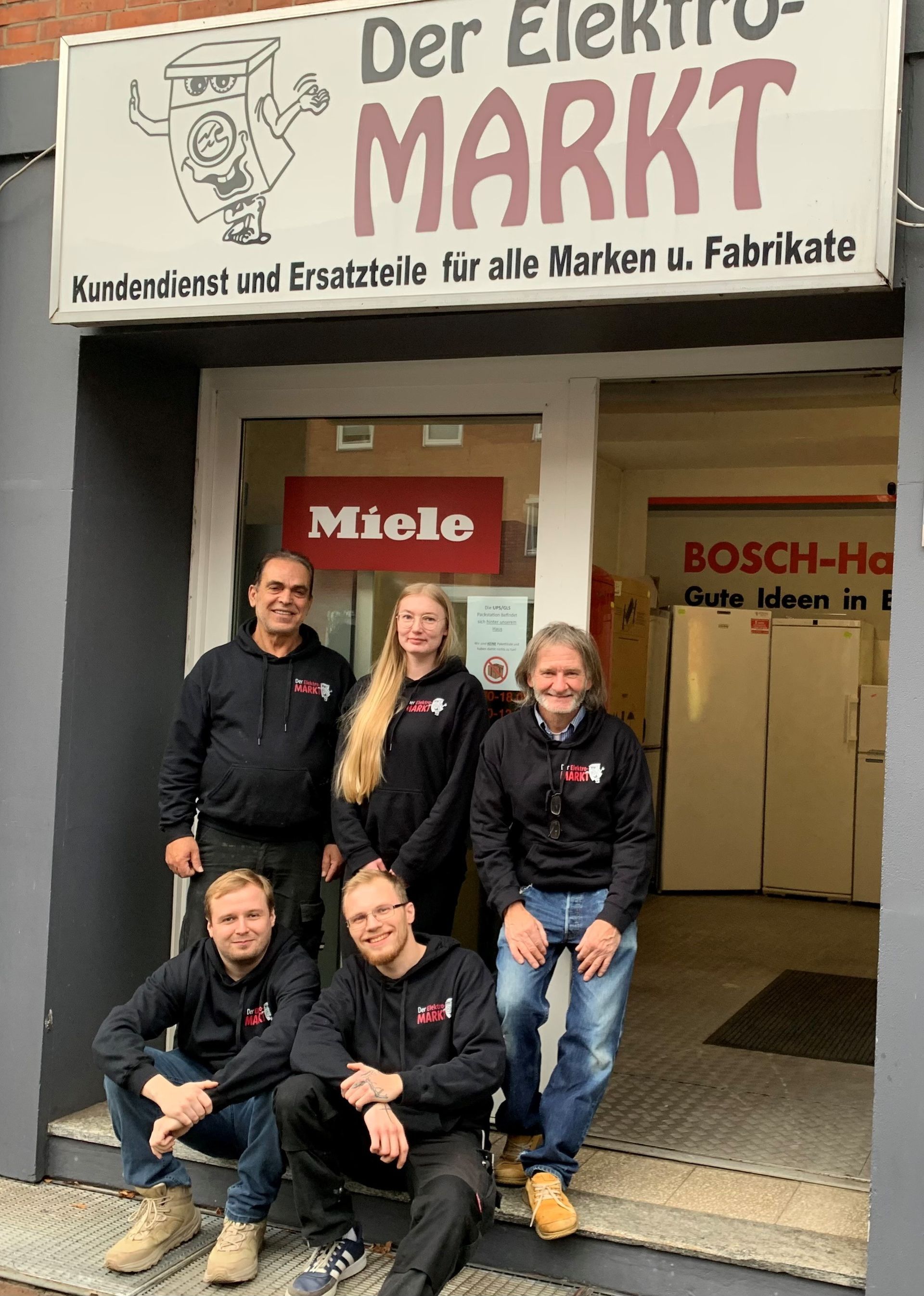 Ein Mann und eine Frau stehen in einem Waschsalon vor Waschmaschinen .