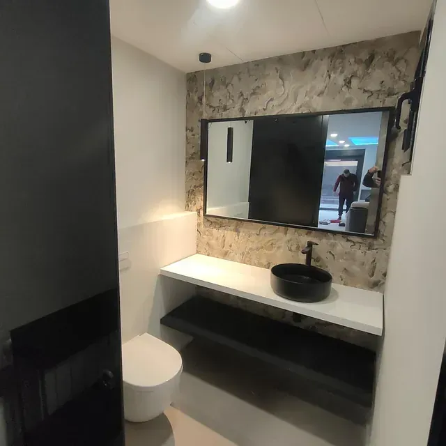 Un baño con inodoro, lavabo y espejo.