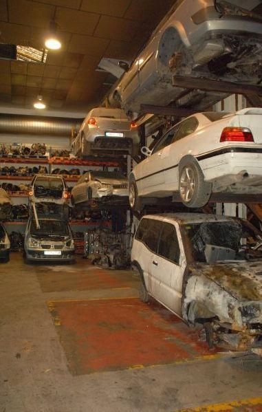 Un montón de coches están apilados uno encima del otro en un garaje.