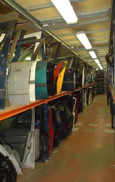 Un montón de puertas de coches están alineadas en los estantes.