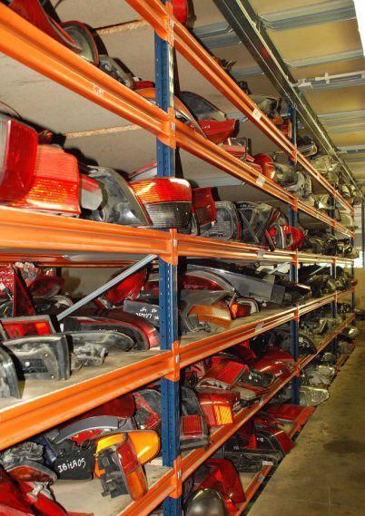 Un almacén lleno de muchas piezas de automóviles, incluidas luces traseras.