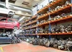 Un almacén lleno de muchos coches y piezas.