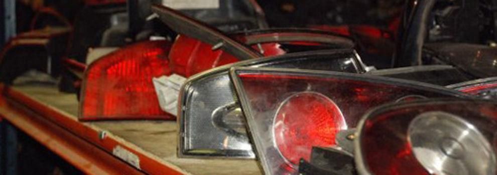 Un montón de luces traseras están en un estante en un almacén.