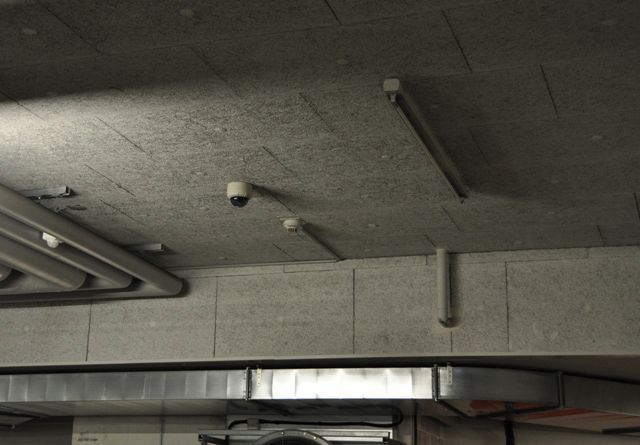 Decke einer Industriegarage mit Rohren, Leuchten und Betonbalken