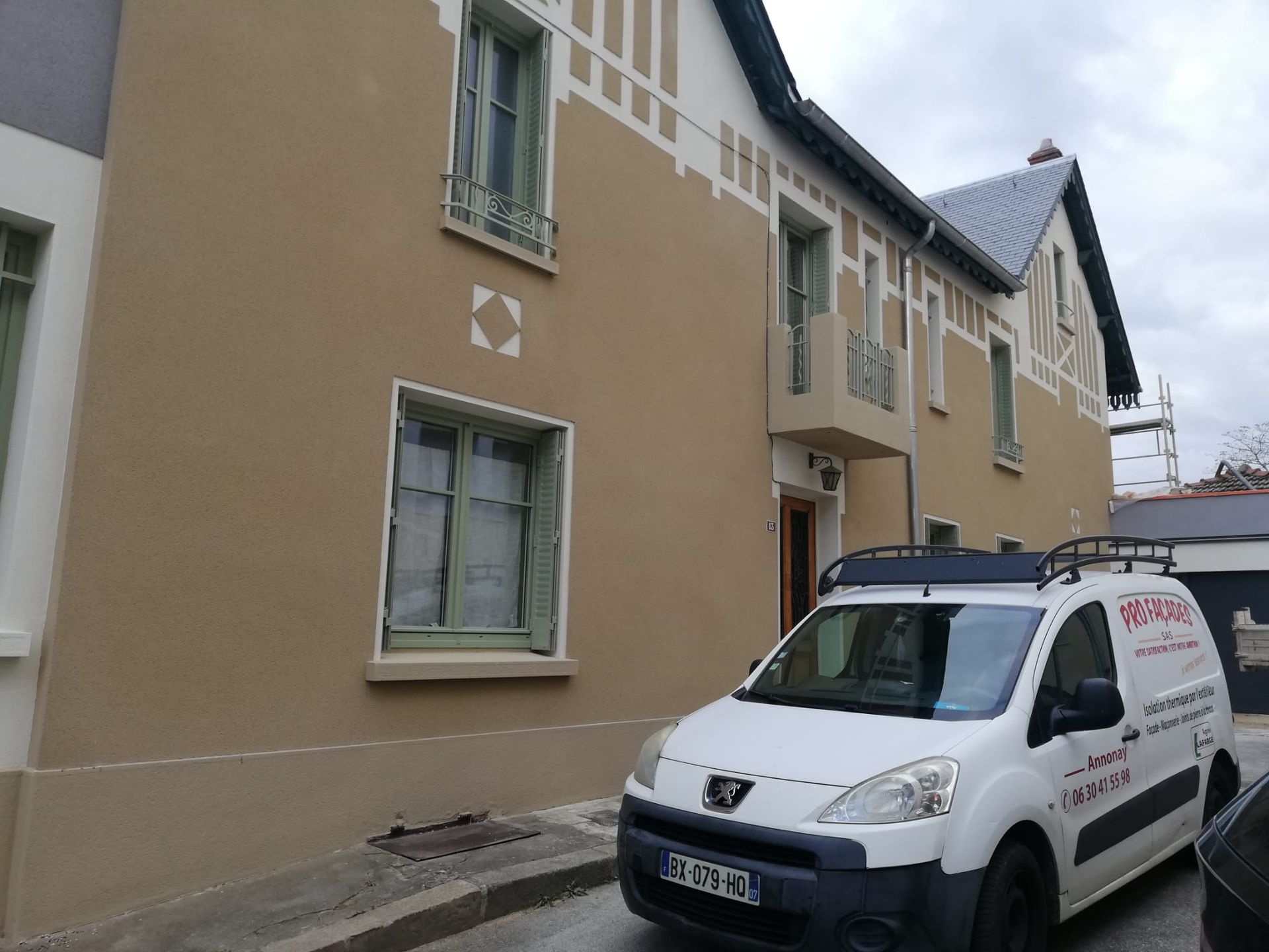 Façade d'un bâtiment rénovée avec la voiture de la société Pro Façades garée devant
