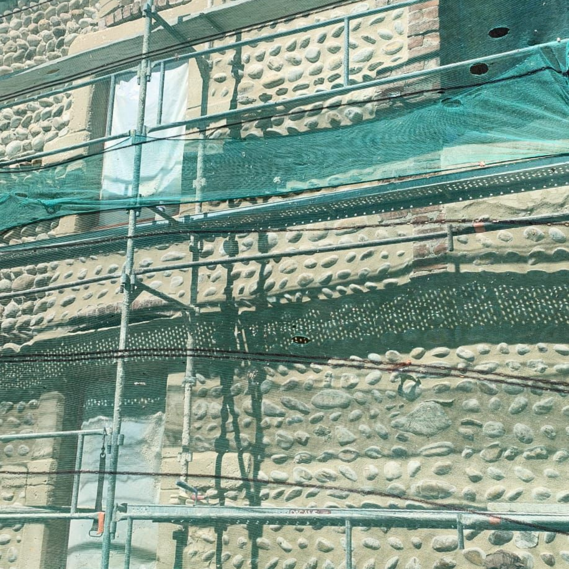 Mur en pierre texturée, aux nuances variées  de beige.