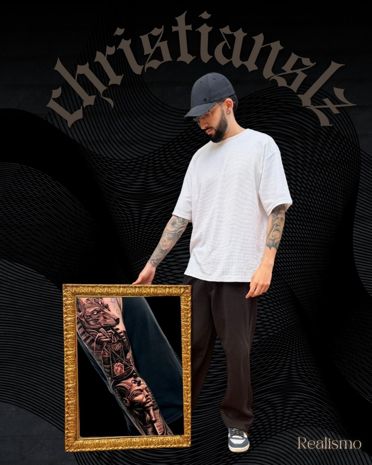 Hombre con camisa blanca y gorra de pie junto a un marco ornamentado que muestra un brazo tatuado sobre un fondo oscuro.