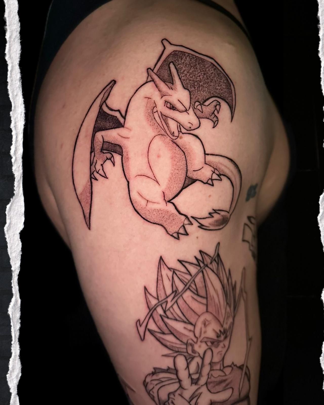 Vista lateral de un brazo con dos tatuajes: un Charizard de alas oscuras y un erizo con púas.