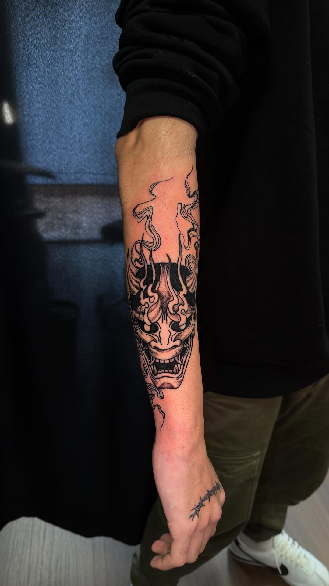 Un tatuaje en tinta negra de una máscara de demonio Hannya japonesa